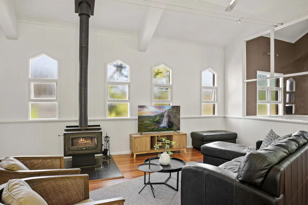 Personalised Painting Solutions located in Croydon, Victoria, painted the Interior of an old church in Whourouly that is an Airbnb, this is a photo of the interior painting in the Lounge room with lancet windows